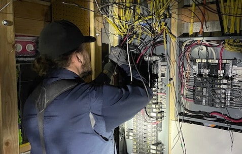 Denver electrician inspecting electrical panel as part of safety inspection