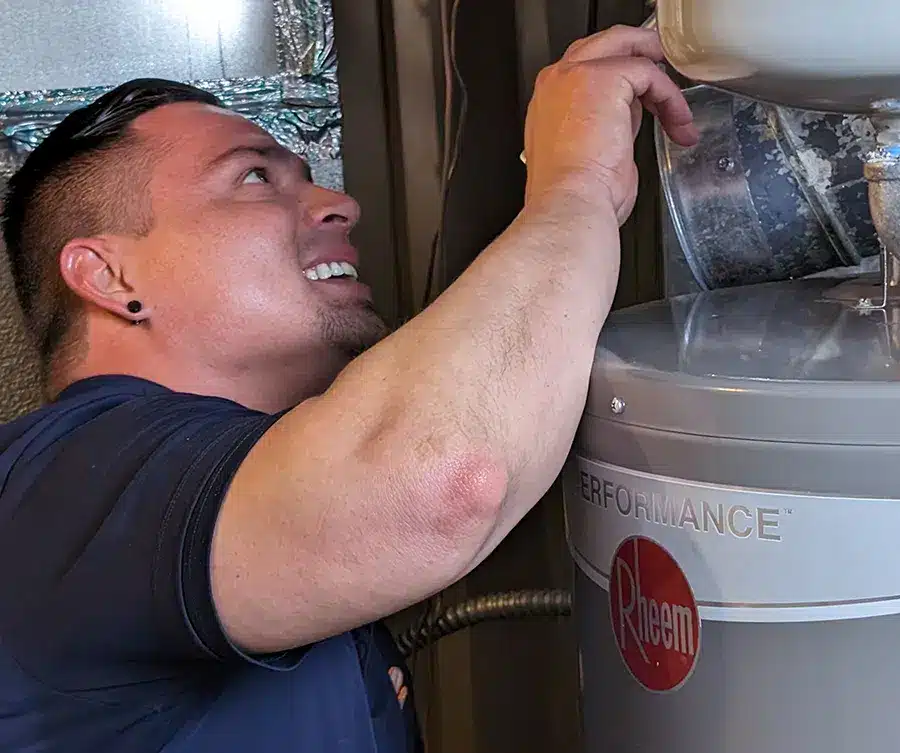 Technician repairing water heater in Denver, CO.