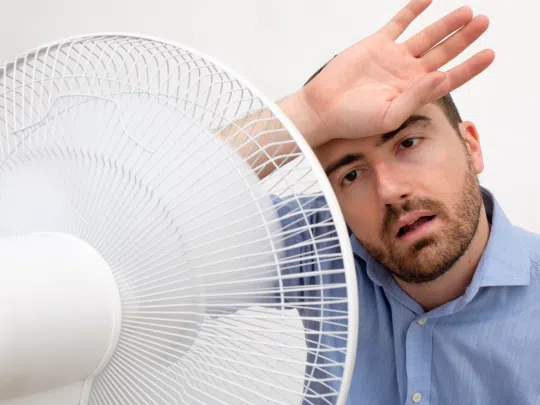 man in front of fan because AC is broken